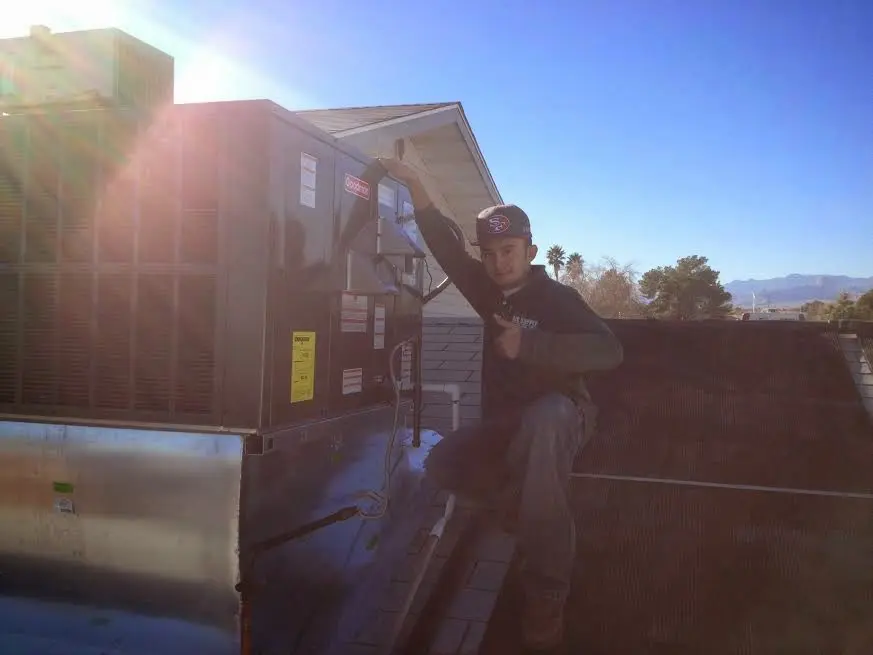 HVAC technician performing HVAC Inspection on a rooftop unit in Gorham
